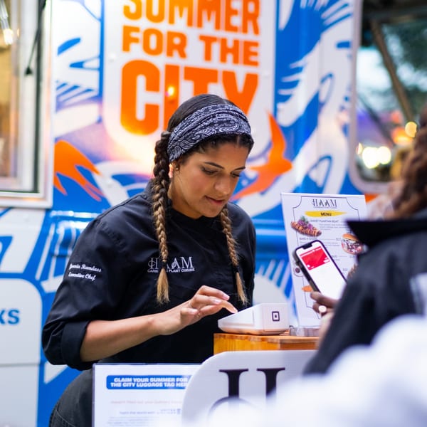 HAAM chef Jovena Ramdass processes a customer's payment at a food truck.