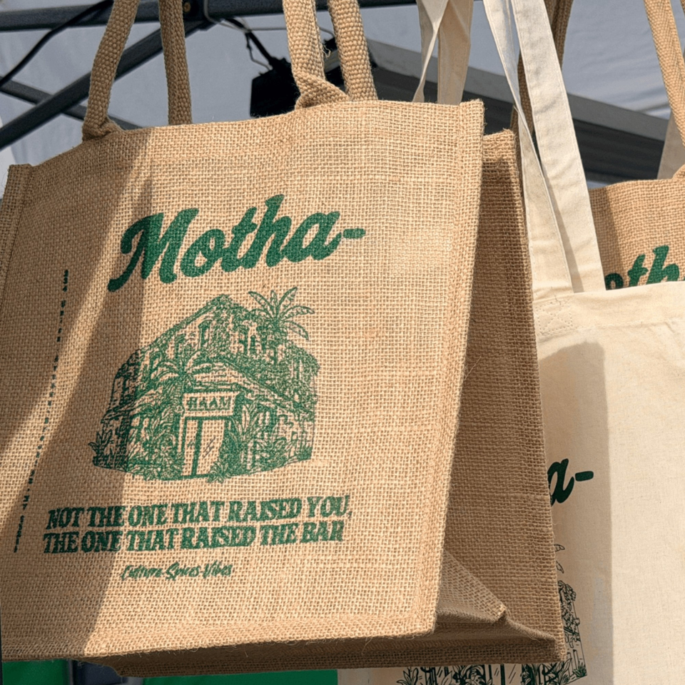HAAM Caribbean Plant Cuisine branded burlap tote bags with green text and a building illustration.